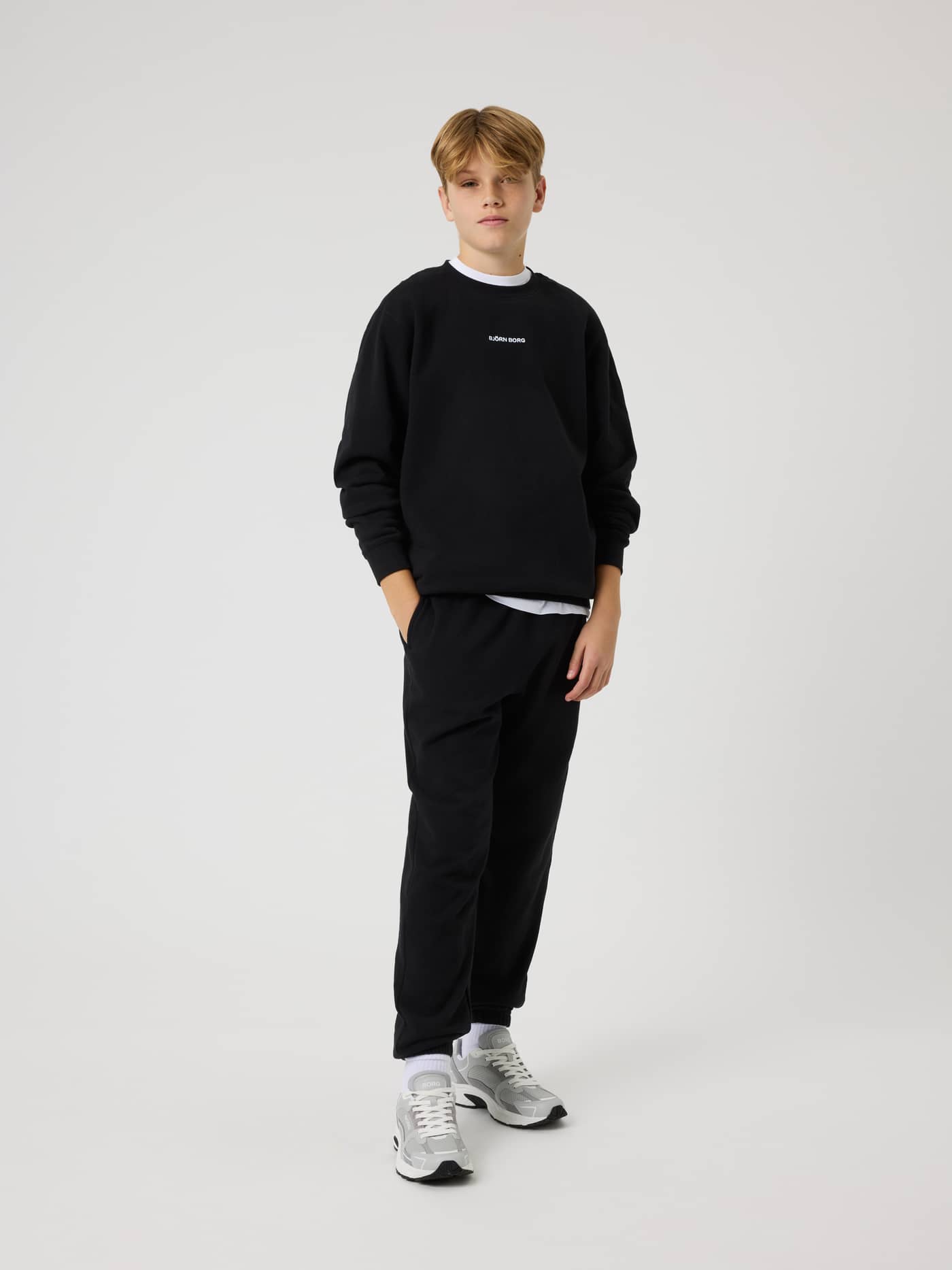 Full-body front view of a model wearing kids Borg Classic Sweatpants in Black Beauty (Black) with a comfortable, relaxed fit. - Image 3