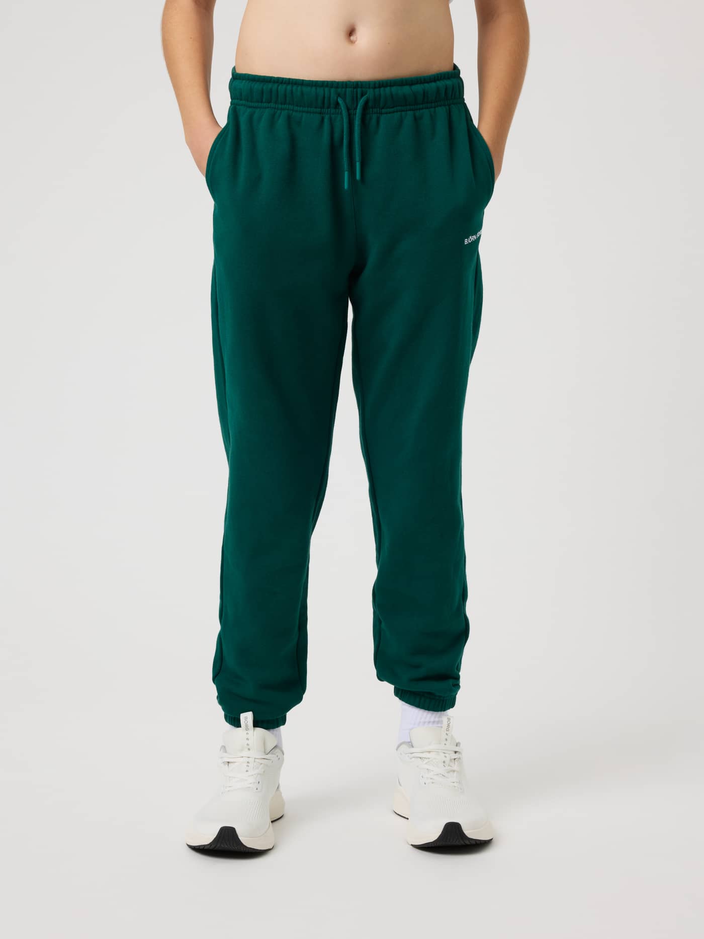 Vista frontal de niños con Borg Classic Sweatpants en Rain Forest (Verde) para tenis, logo blanco y cintura con cordón. - Image 1
