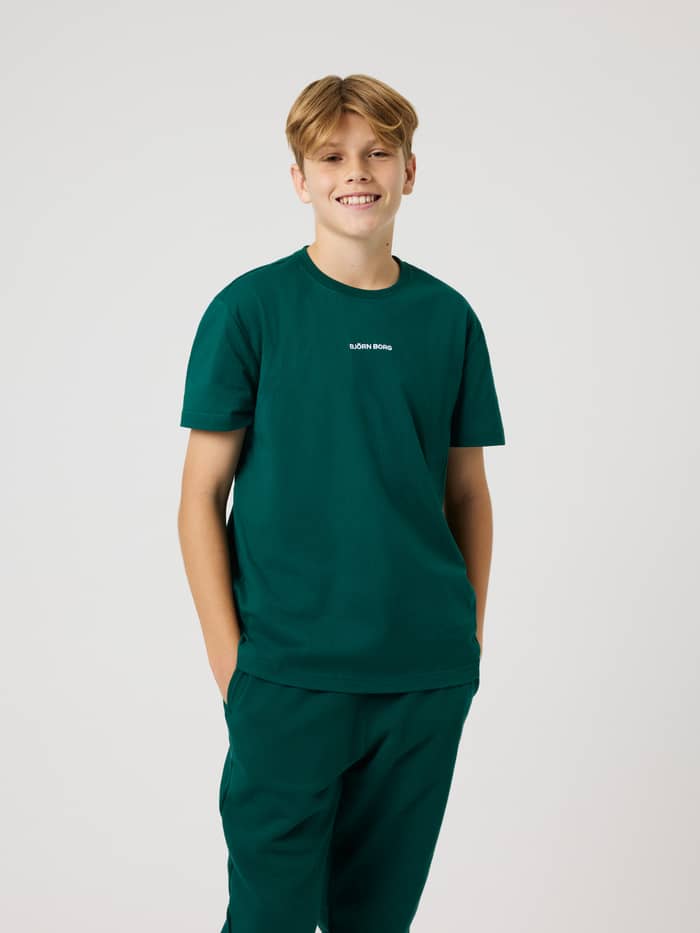 Front view of a boy wearing the Borg Classic T-Shirt in Rain Forest (Green) with a white chest logo for kids training.