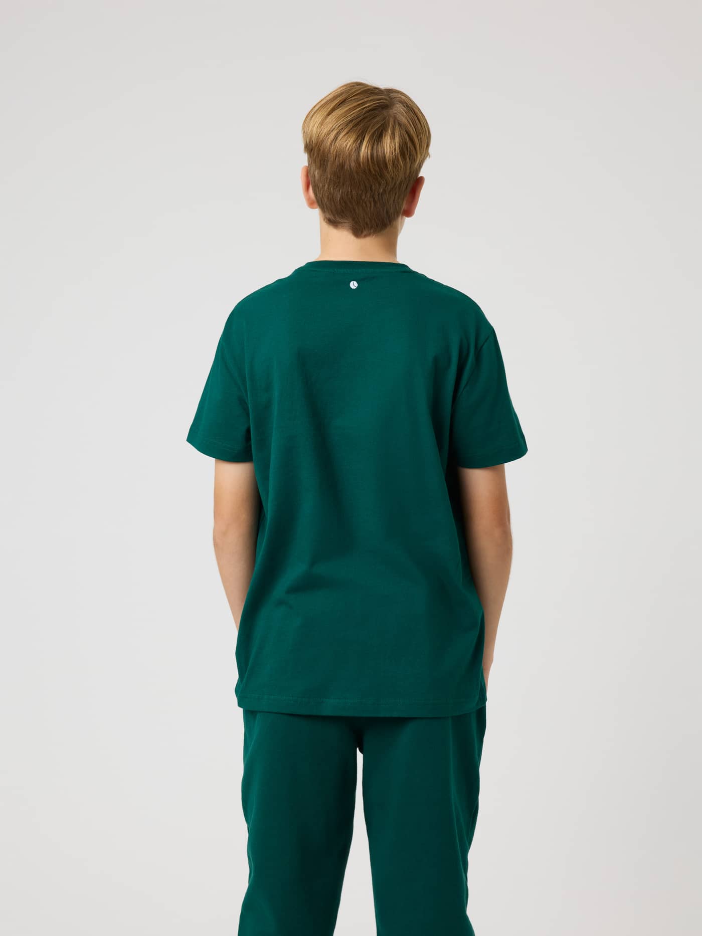 Back view of the kids Borg Classic T-Shirt in Rain Forest (Green) featuring a tennis ball print at the back neck. - Image 2