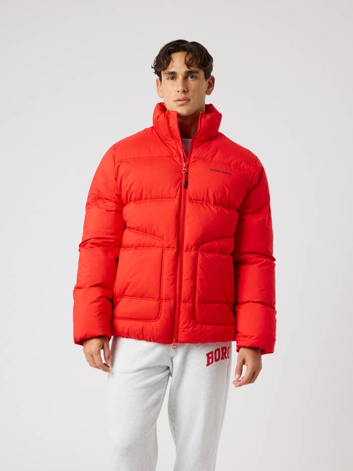 Front view of a model wearing the Borg Puffer Jacket in Flame Scarlet (Red) for cold-weather training and movement.