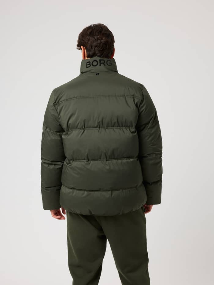 Back view of the Borg Puffer Jacket in Rosin (Green) featuring a black logo on the collar for tennis and training. - Image 2