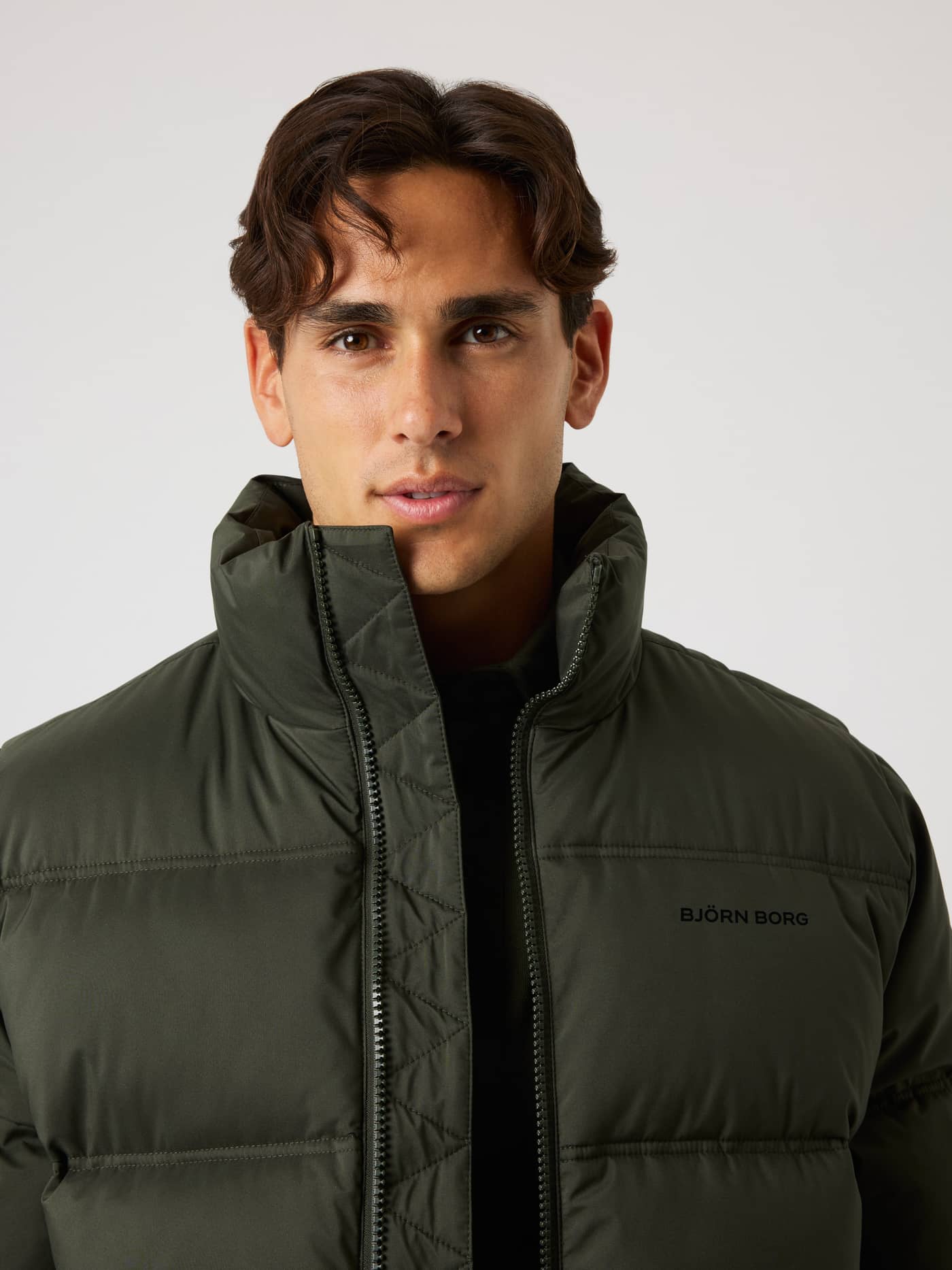 Borg Puffer Jacket i Rosin (Grønn) med høy krage og svart logo på brystet, perfekt for utendørs vintertrening. - Image 5