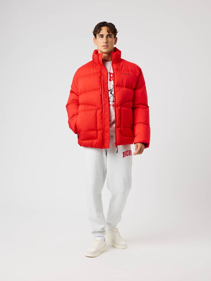 Front view of a model wearing the Borg Puffer Jacket in Flame Scarlet (Red) with a black logo for training. - Image 3