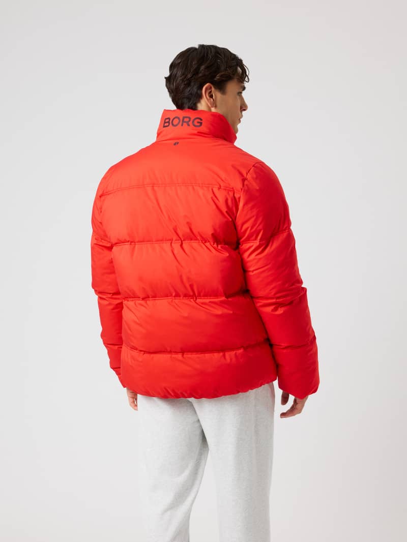 Back view of a man wearing the Borg Puffer Jacket in Flame Scarlet (Red) with a padded design and logo for training. - Image 2