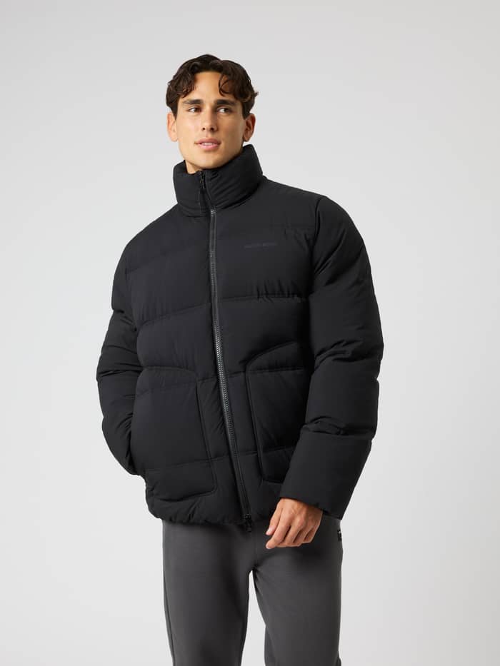 Front view of a man in the Borg Puffer Jacket in Black Beauty (Black), a padded jacket for training and movement.