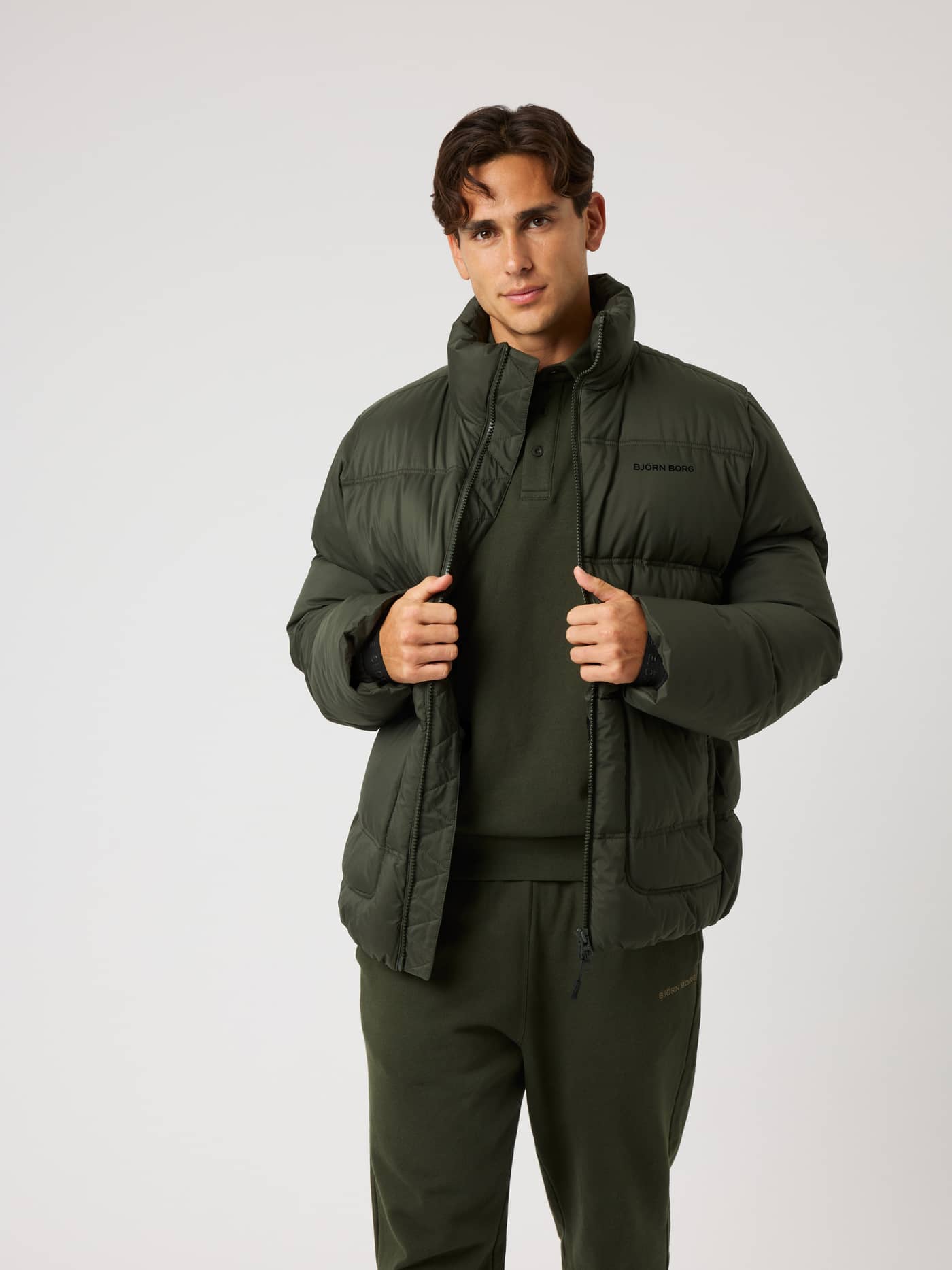 Borg Puffer Jacket i Rosin (Grønn) sett forfra med svart logo, vattert for trening og pendling til gymmet. - Image 1
