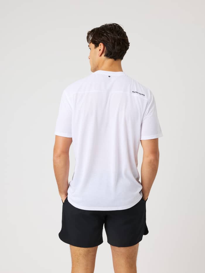 Back view of a man in the Borg Soft Sports T-Shirt in Brilliant White (White) with a black logo for training or tennis. - Image 2