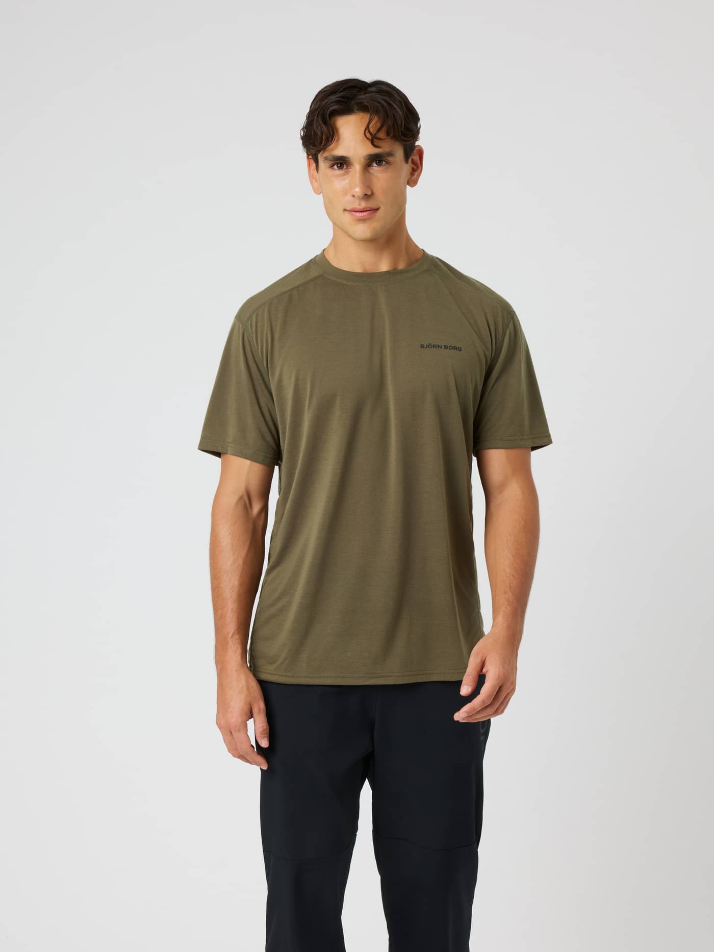 Vue de face d'un modèle en Borg Soft Sports T-Shirt en Kalamata (Vert) avec un logo noir pour le training et le tennis. - Image 1