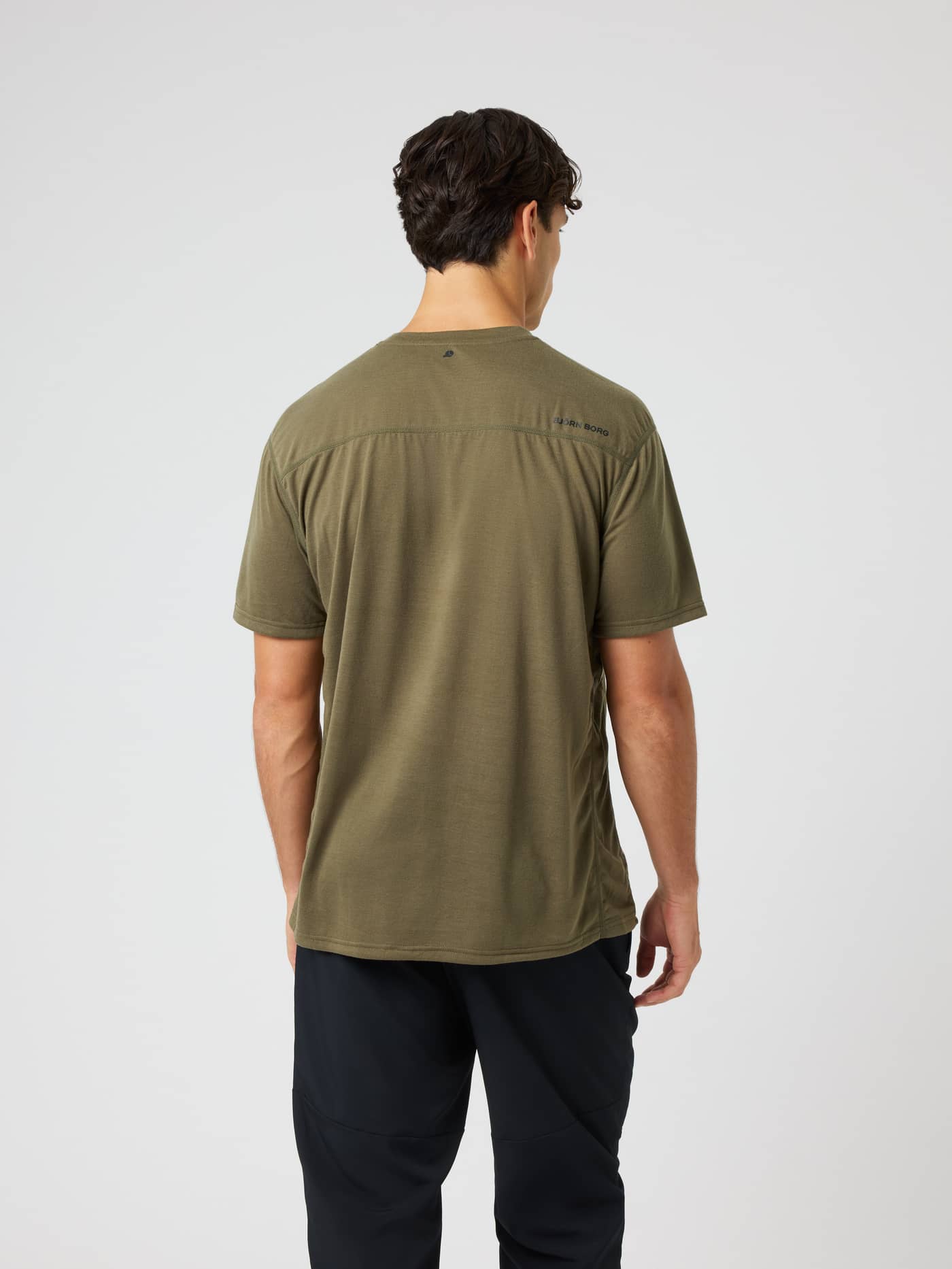 Back view of a model wearing the Borg Soft Sports T-Shirt in Kalamata (Green) with black logo prints for training. - Image 2