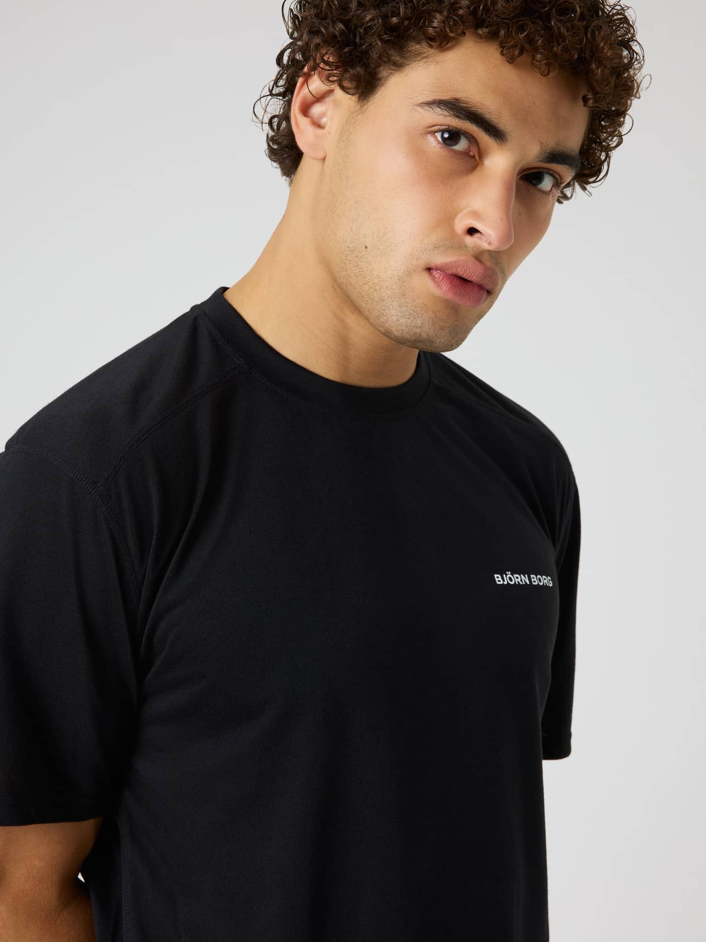 Gros plan sur le Borg Soft Sports T-Shirt en Black Beauty (Noir) avec un logo blanc pour le training. - Image 1
