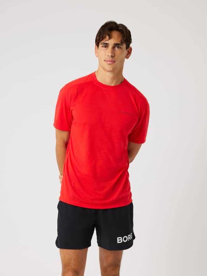 Front view of a model wearing the Borg Soft Sports T-Shirt in Flame Scarlet (Red) for training and tennis.