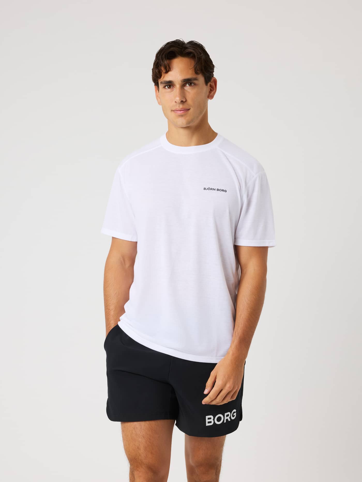 Vue de face d'un modèle en Borg Soft Sports T-Shirt en Brilliant White (Blanc) avec un logo noir pour le training. - Image 1