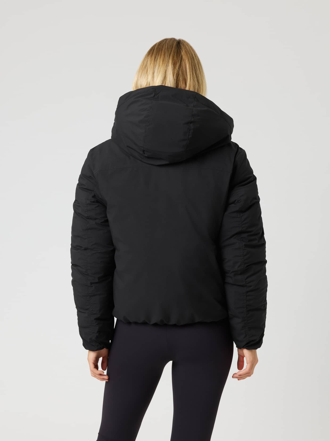 Studio Reversible Puffer Jacket i Black Beauty (Svart) sett bakfra på modell, vattert jakke med hette. - Image 2