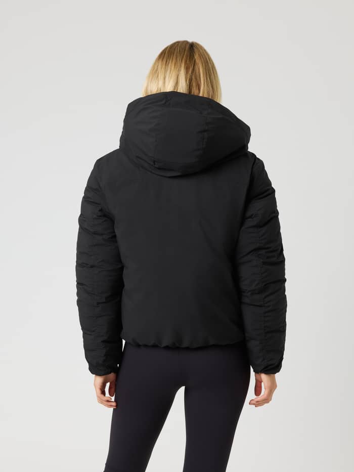 Vue arrière d'un mannequin portant la Studio Reversible Puffer Jacket en Black Beauty (Noir) matelassée avec capuche. - Image 2