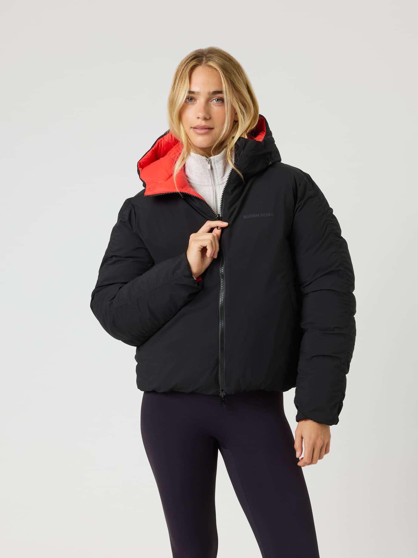 Studio Reversible Puffer Jacket i Black Beauty (Svart) med rødt fôr, quiltet design og svart logo, sett forfra. - Image 1