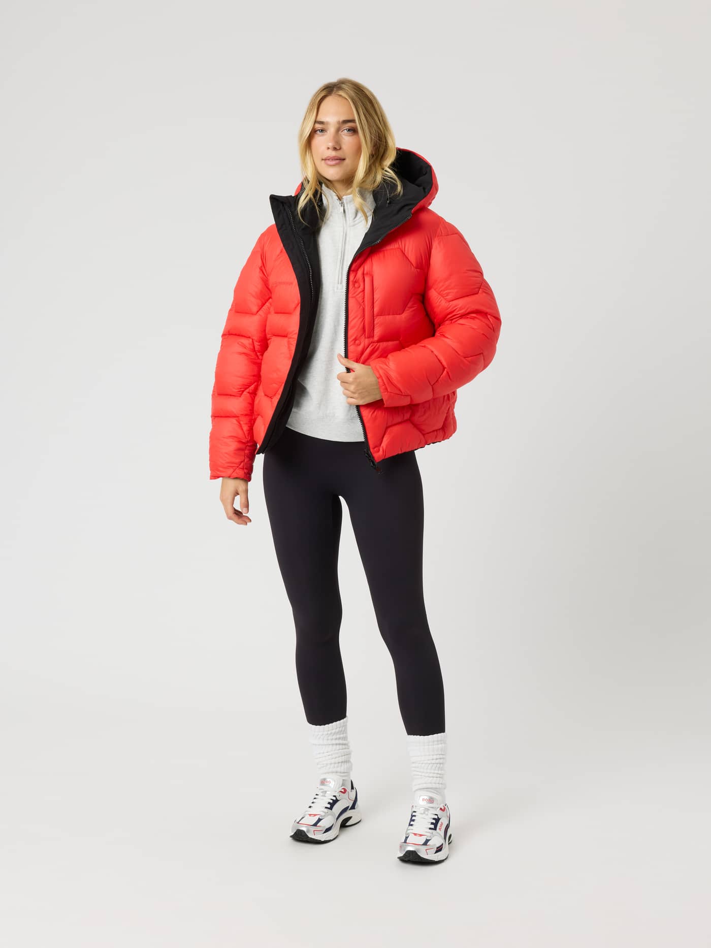 Studio Reversible Puffer Jacket i Black Beauty (Svart) på modell med unikt rødt vattert mønster og hette. - Image 7