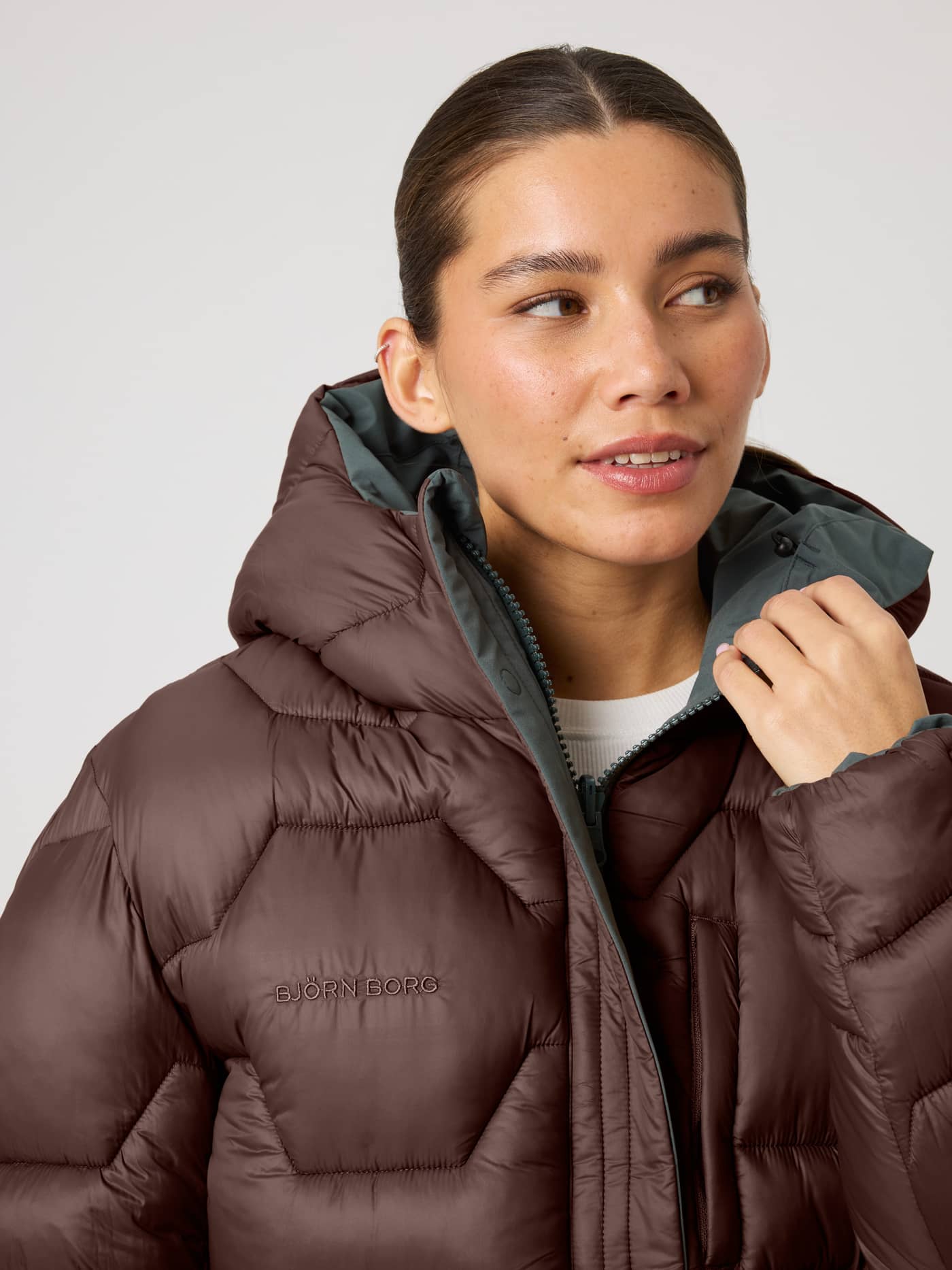 Studio Reversible Puffer Jacket i Urban Chic (Grønn) med vattert mønster og ton-i-ton-brodert logo på brystet. - Image 1