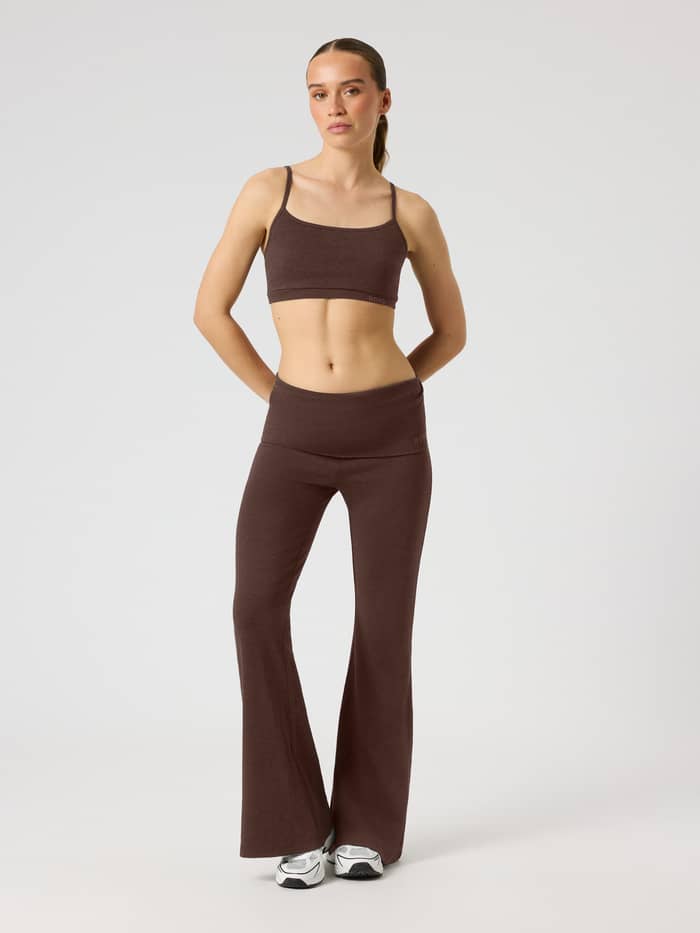 Full-body front view of a model wearing Studio Flow Folded Flare Tights in Coffee Bean (Brown) for studio training.