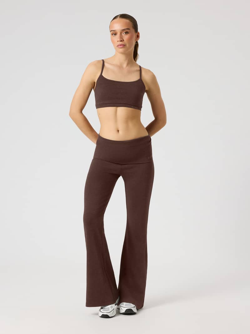 Full-body front view of a model wearing Studio Flow Folded Flare Tights in Coffee Bean (Brown) for studio training.