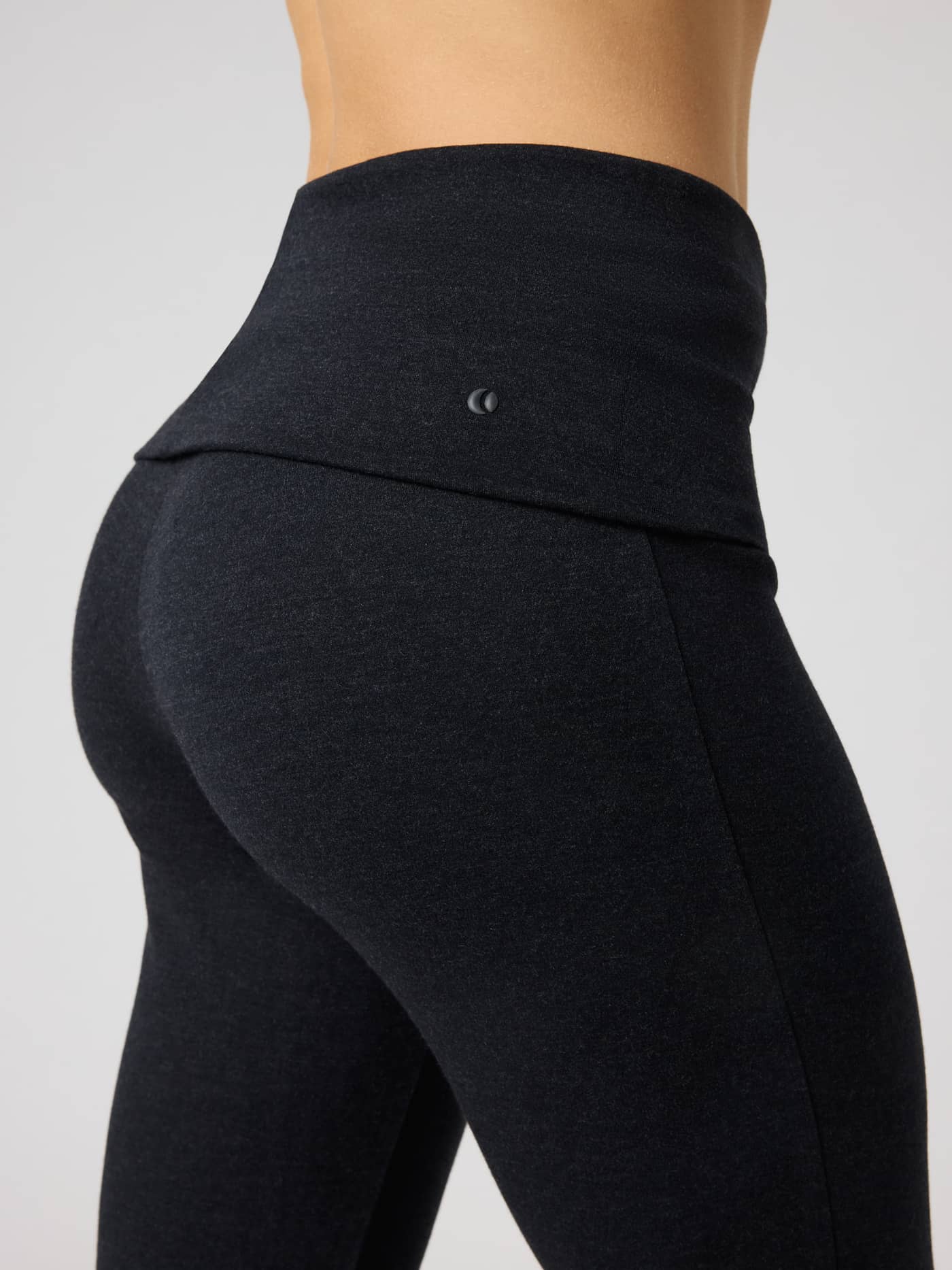 Studio Flow Folded Flare Tights in Black Beauty (Black) for training, showing the soft fabric and black tennis logo. - Image 4