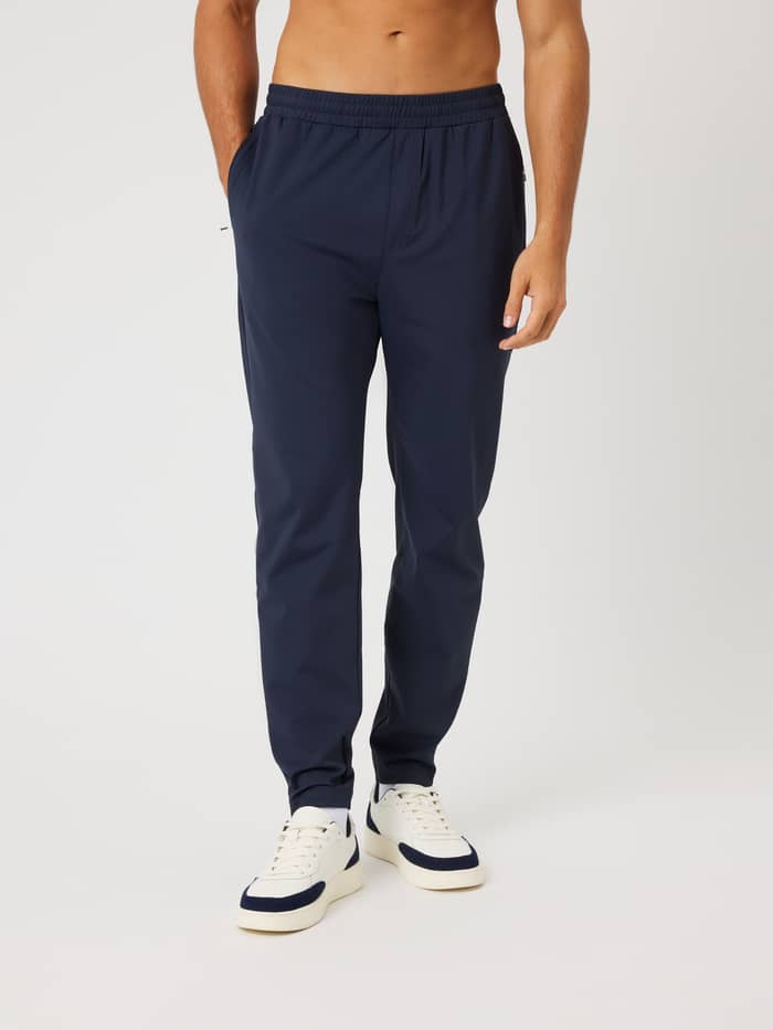 Vooraanzicht van een man in de Ace Court Pants in Night Sky (Marineblauw) voor tennistraining en flexibele beweging.