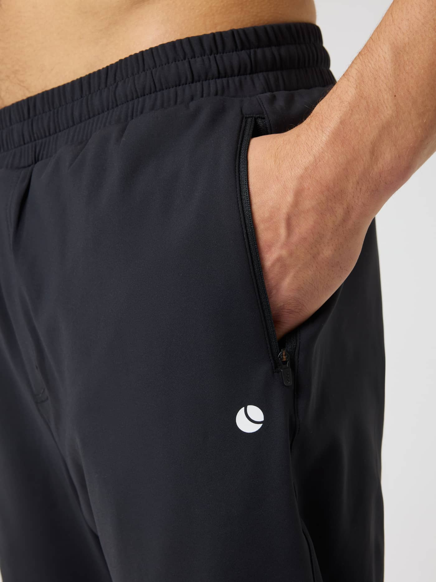Ace Court Pants in Black Beauty (Black) for tennis training, showing side zip pocket and white tennis ball logo. - Image 4