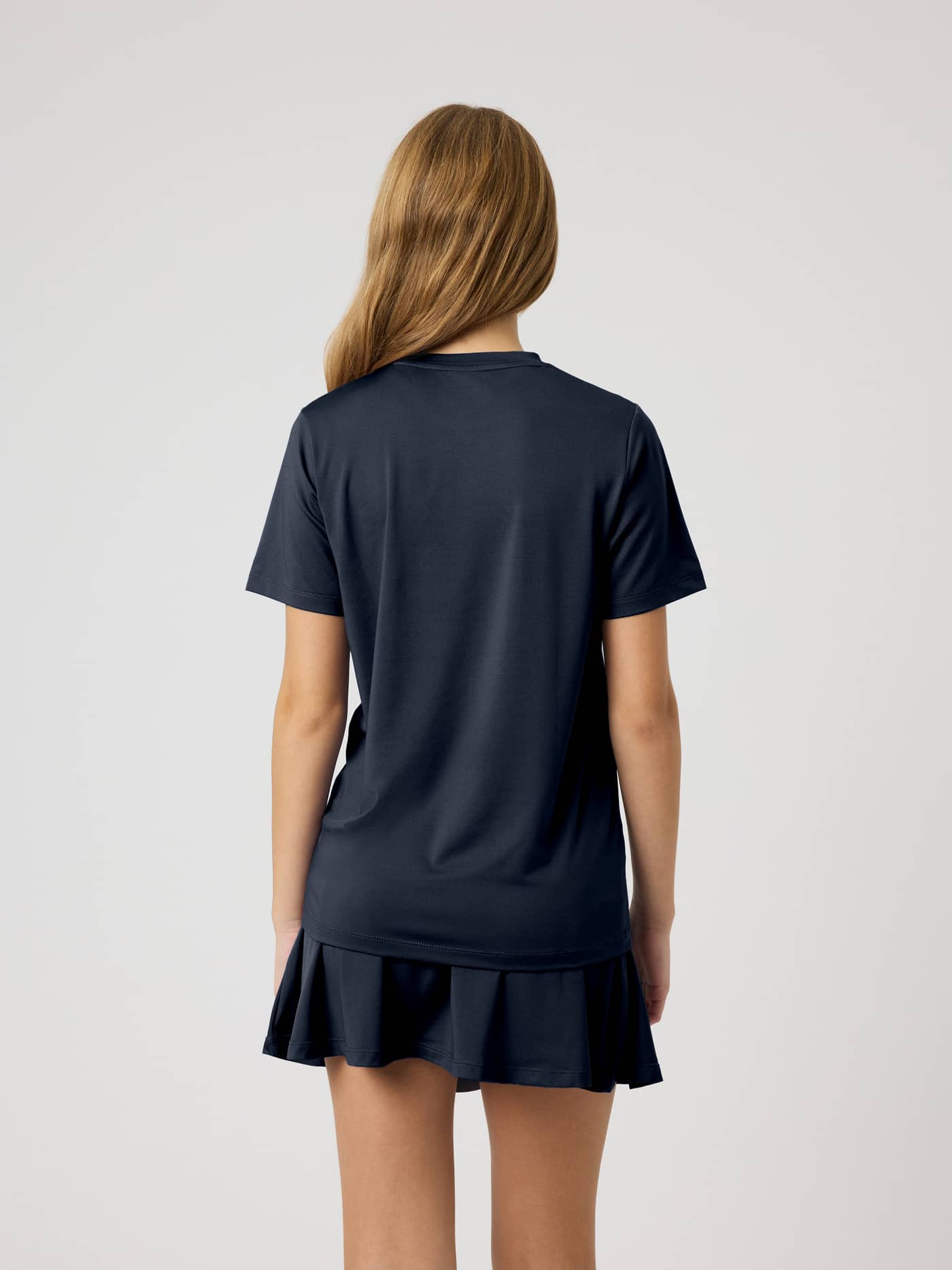 Back view of a kid wearing the Ace Slim T-Shirt in Night sky (Navy), a slim fit functional top for tennis movement. - Image 5