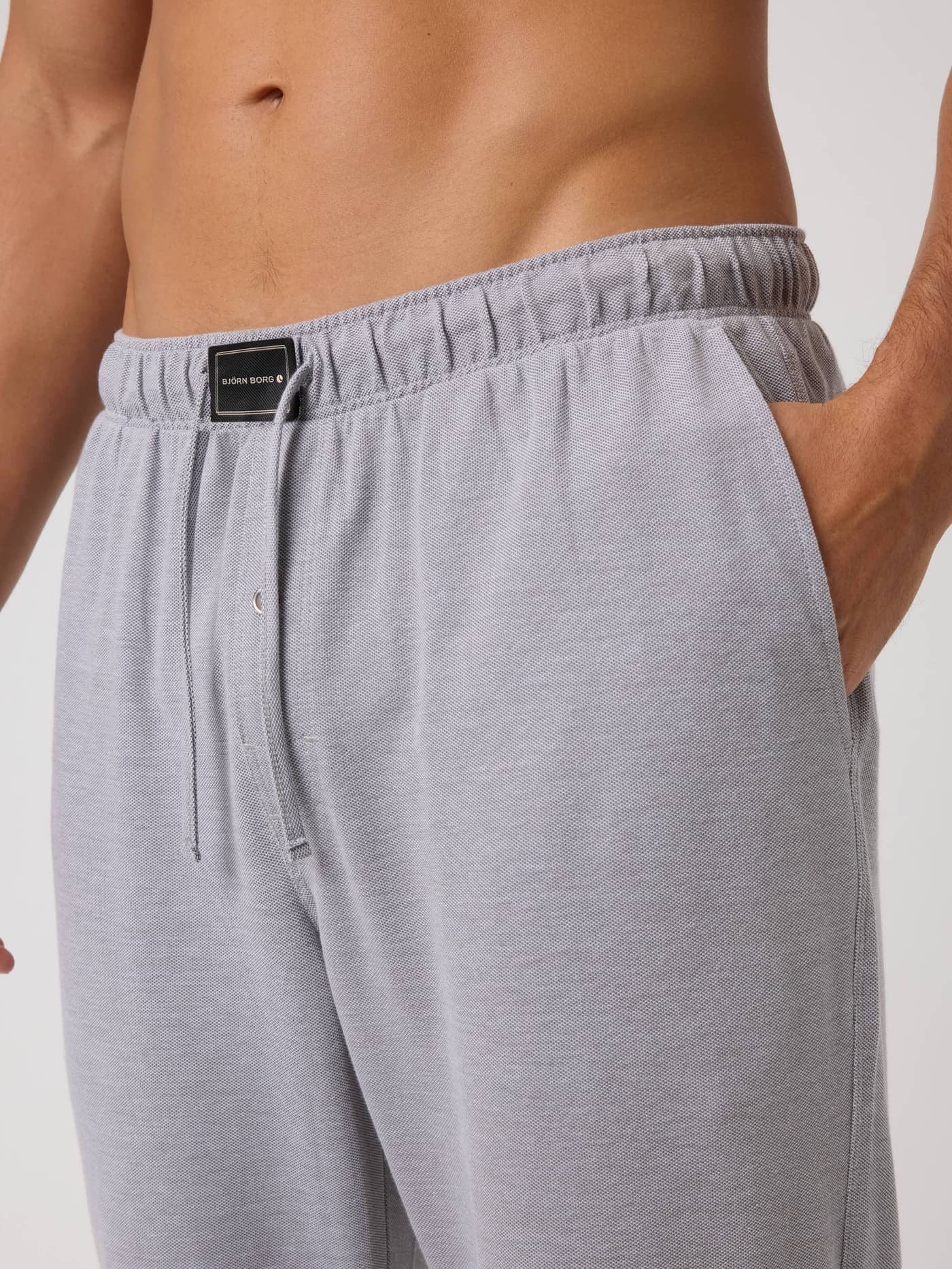 Close-up of Core Pique Pyjama Pants in Charcoal Gray (Grey) with a textured piqué finish and a black logo at the waist. - Image 4