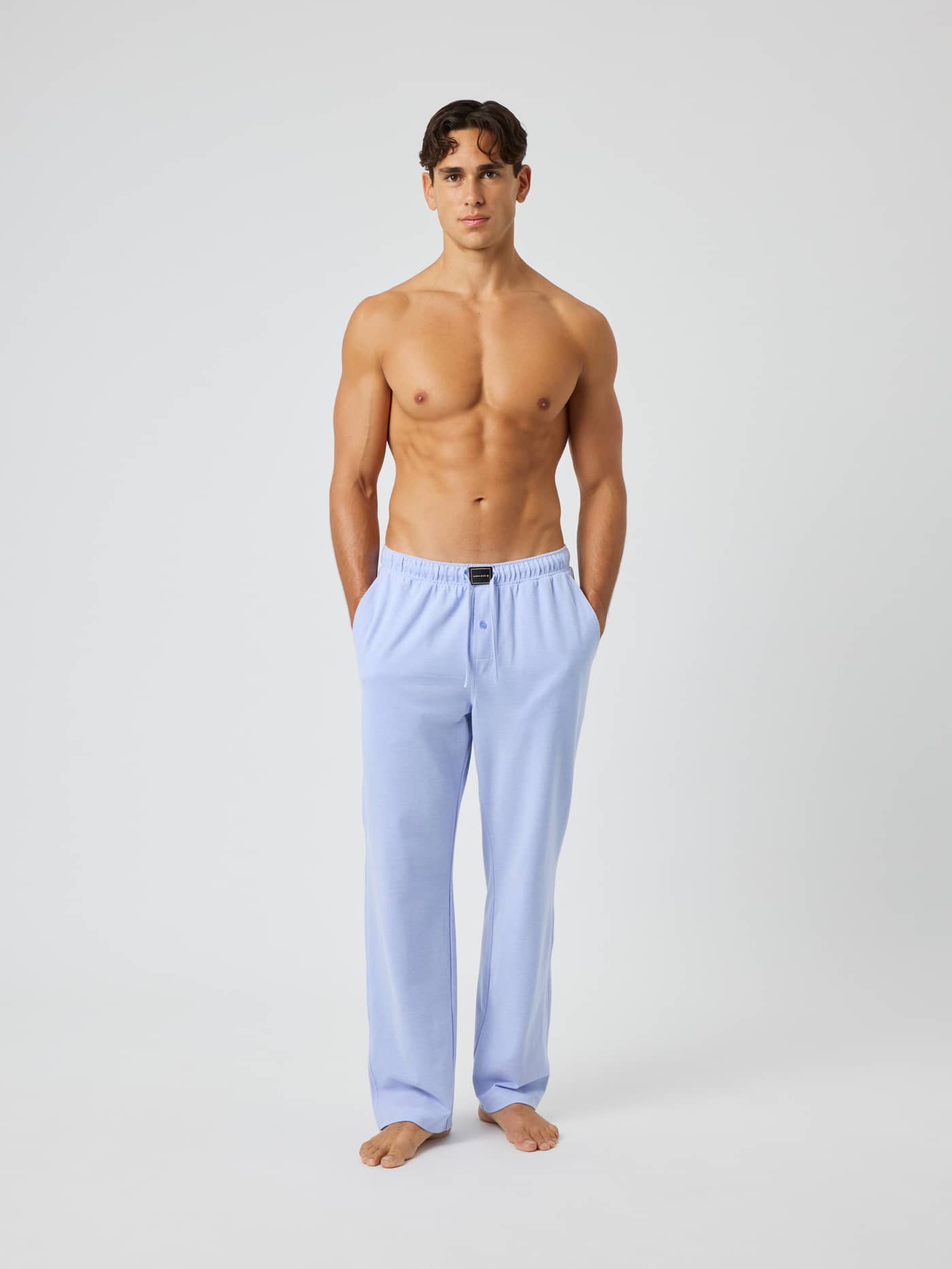 Front view of a man wearing Core Pique Pyjama Pants in Lavender Lustre (Purple) with a black logo on the waistband. - Image 4