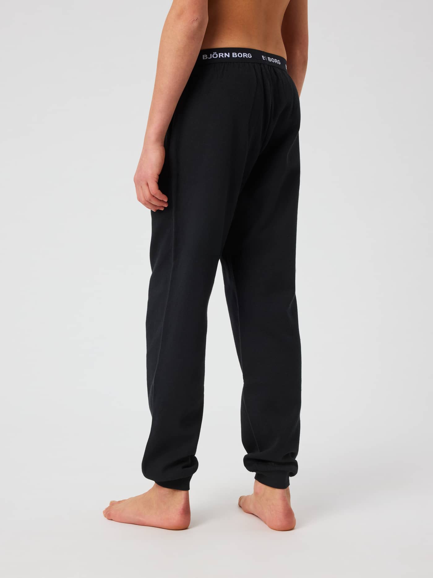 Kids Core Loungewear Pants in Black Beauty (Black) seen from behind, featuring a white Björn Borg logo on the waistband. - Image 2