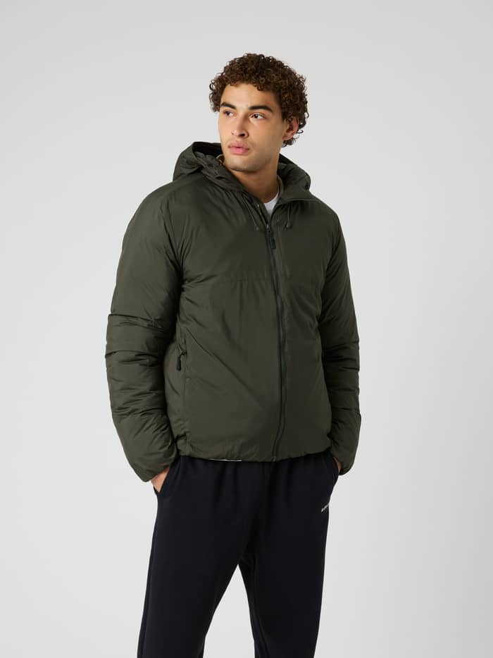 Vue de face d'un homme portant la Borg Liner Hood Jacket en Rosin (Vert), une veste d'entraînement matelassée à capuche.