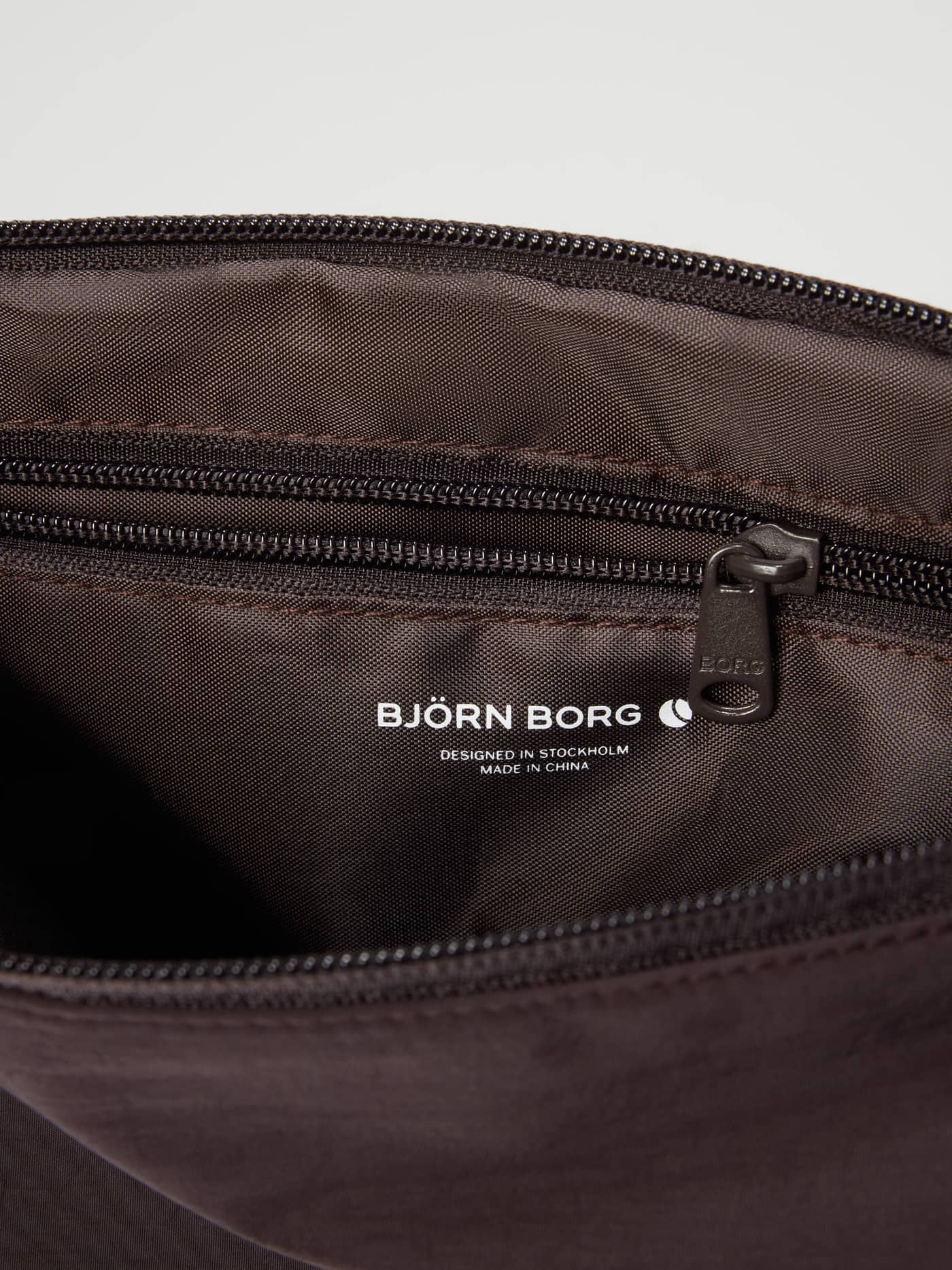 Interior of the Studio Active Wash Bag Set in Coffee Bean (Brown) for training, with a white logo and zip pocket. - Image 4