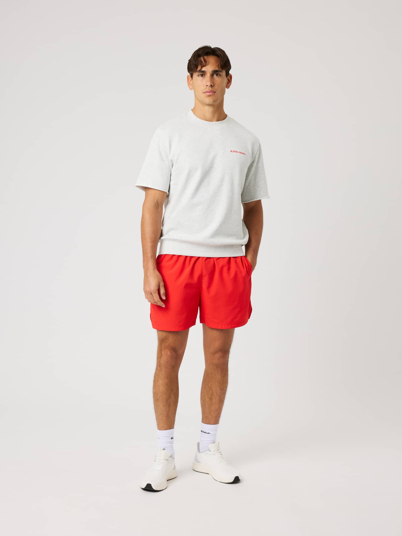 Front view of a model in the Borg Oversized Short Sleeve Sweatshirt in Ultra Light Grey Melange (Grey) with a red logo. - Image 4