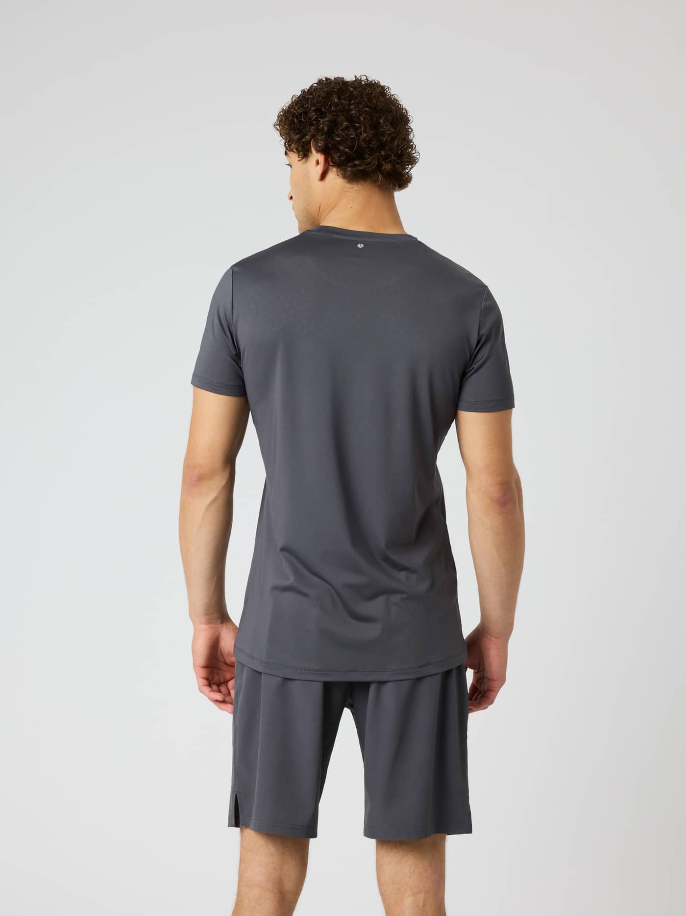 Back view of a man wearing the Borg Graphic T-Shirt in Asphalt (Grey), a training shirt with a tennis ball print. - Image 2