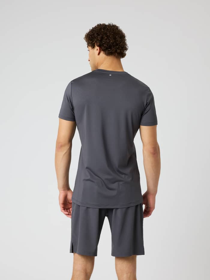 Back view of a man wearing the Borg Graphic T-Shirt in Asphalt (Grey), a training shirt with a tennis ball print. - Image 2
