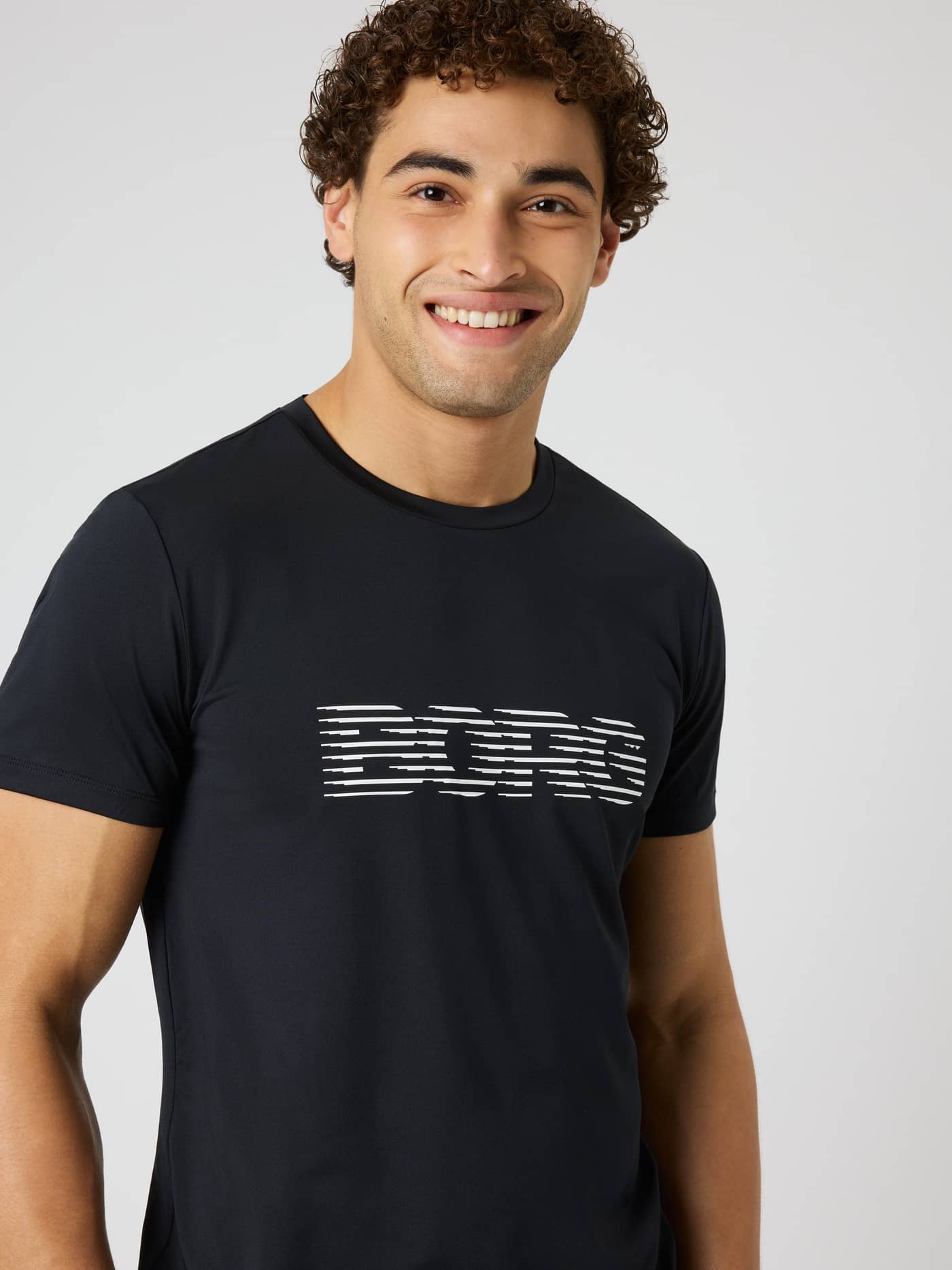 Borg Graphic T-Shirt in Black Beauty (Black) on a model, featuring a white graphic chest logo for training. - Image 6