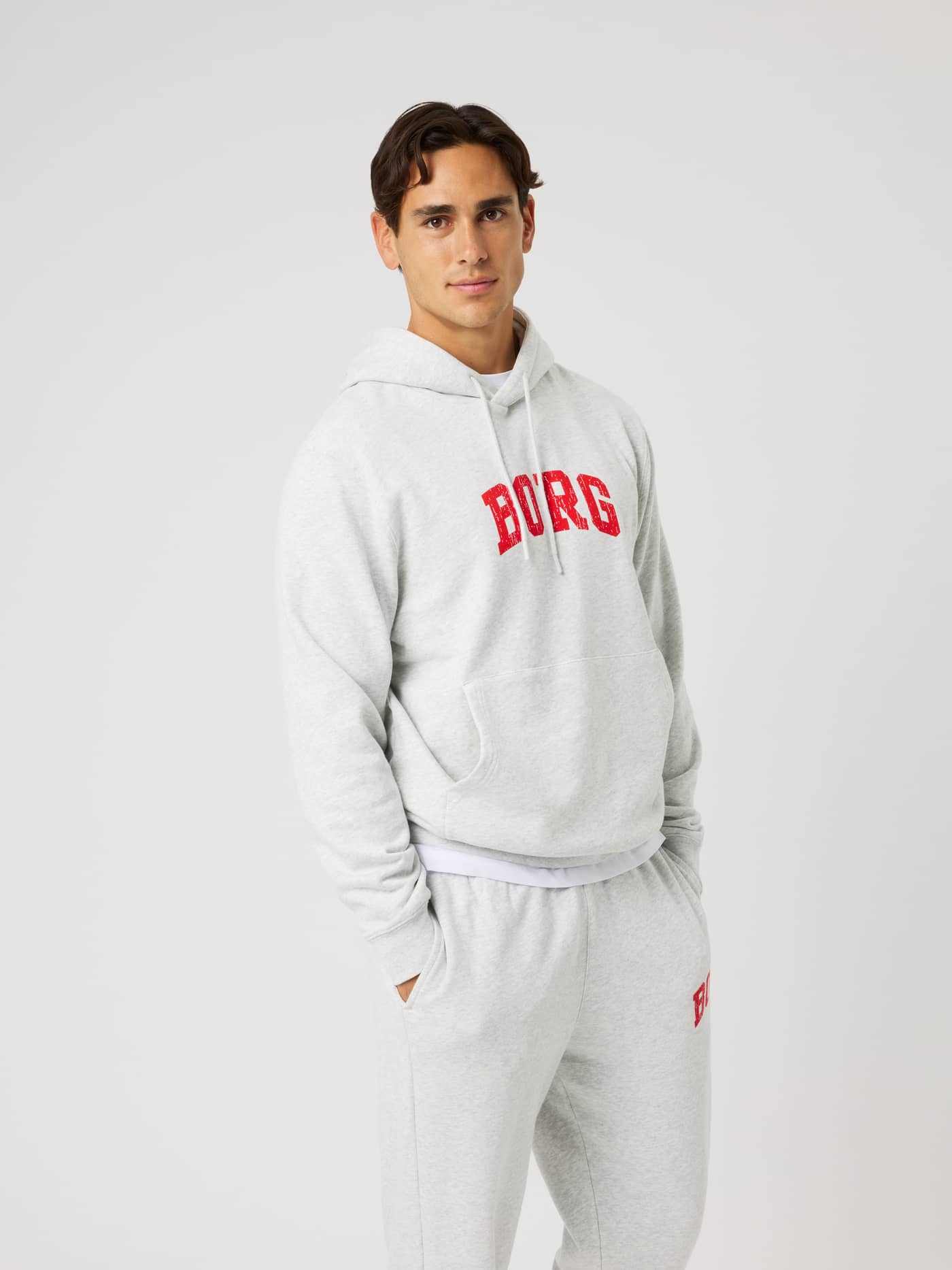 Vue de face d'un modèle en Borg Classic Print Hoodie Ultra Light Grey Melange (Gris) au logo rouge pour le training. - Image 1