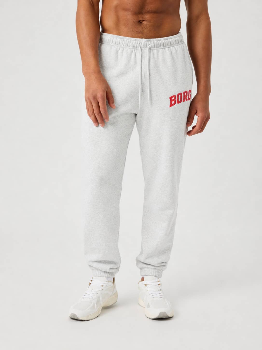 Vue de face d'un modèle en Borg Classic Print Sweatpants Ultra Light Grey Melange (Gris) avec logo rouge et style tennis. - Image 1