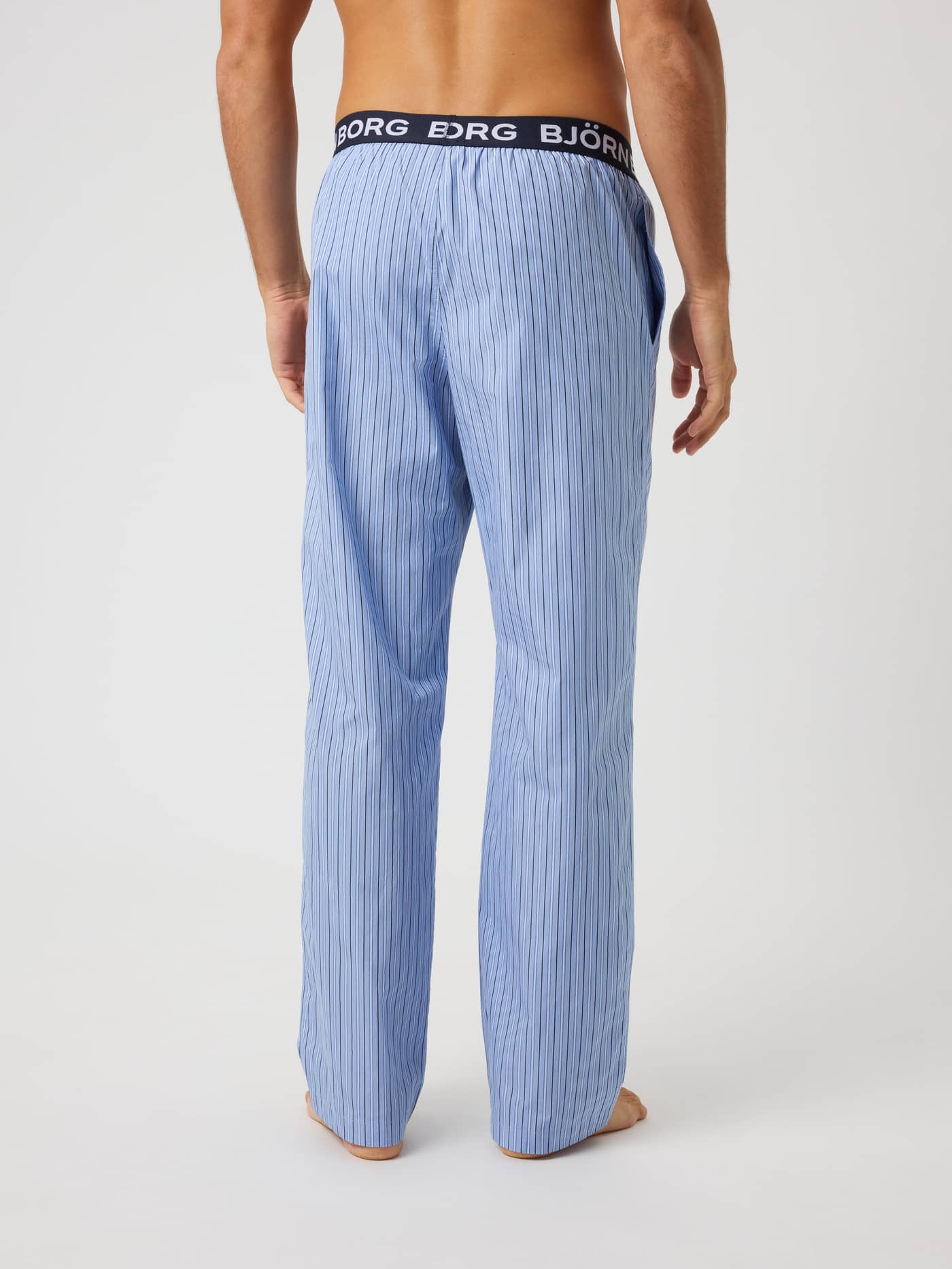 Back view of Core Woven Logo Pyjama Pants in Tripple Lw Stripe 2 (Blue) cotton featuring stripes and a white logo waistband. - Image 2