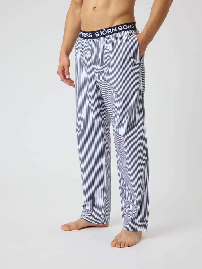 Core Woven Logo Pyjama Pants i Fresh Stripe 5 (Blå) sett fra siden med striper og svart linning med hvite logoer.