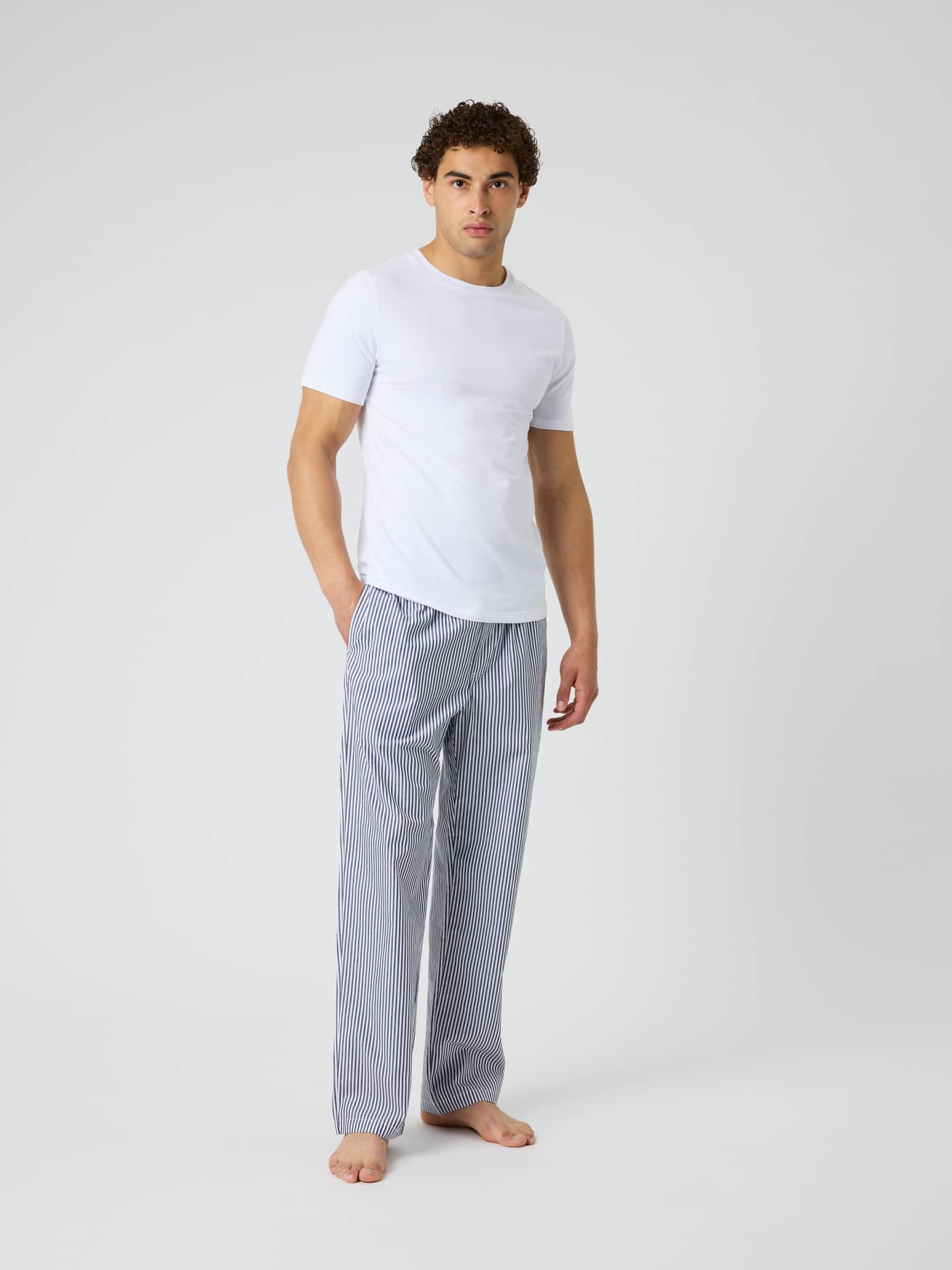 Front view of a man wearing Core Woven Logo Pyjama Pants in BB Fresh Stripe 5 (Blue) with a classic striped pattern. - Image 3