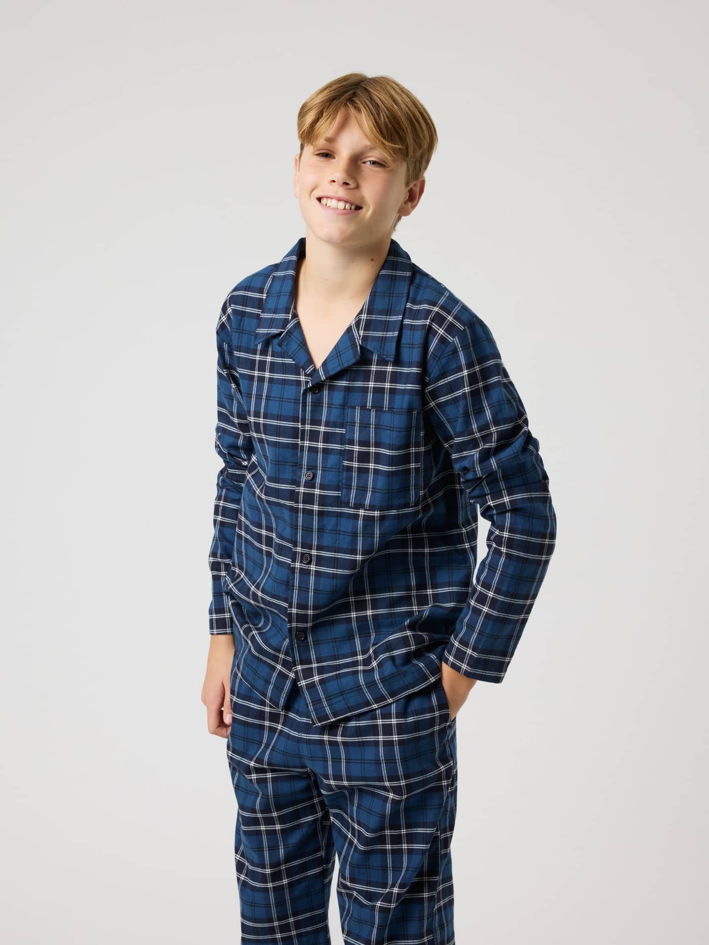 Front view of a boy wearing the Björn Borg Core Flannel Pyjama Shirt for kids in Forest Tartan 4 (Blue) with a check pattern. - Image 3