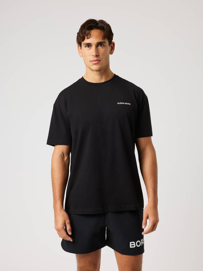 Front view of a model in the Borg Gym Oversized T-Shirt in Black Beauty (Black) with a white chest logo for gym training. - Image 2