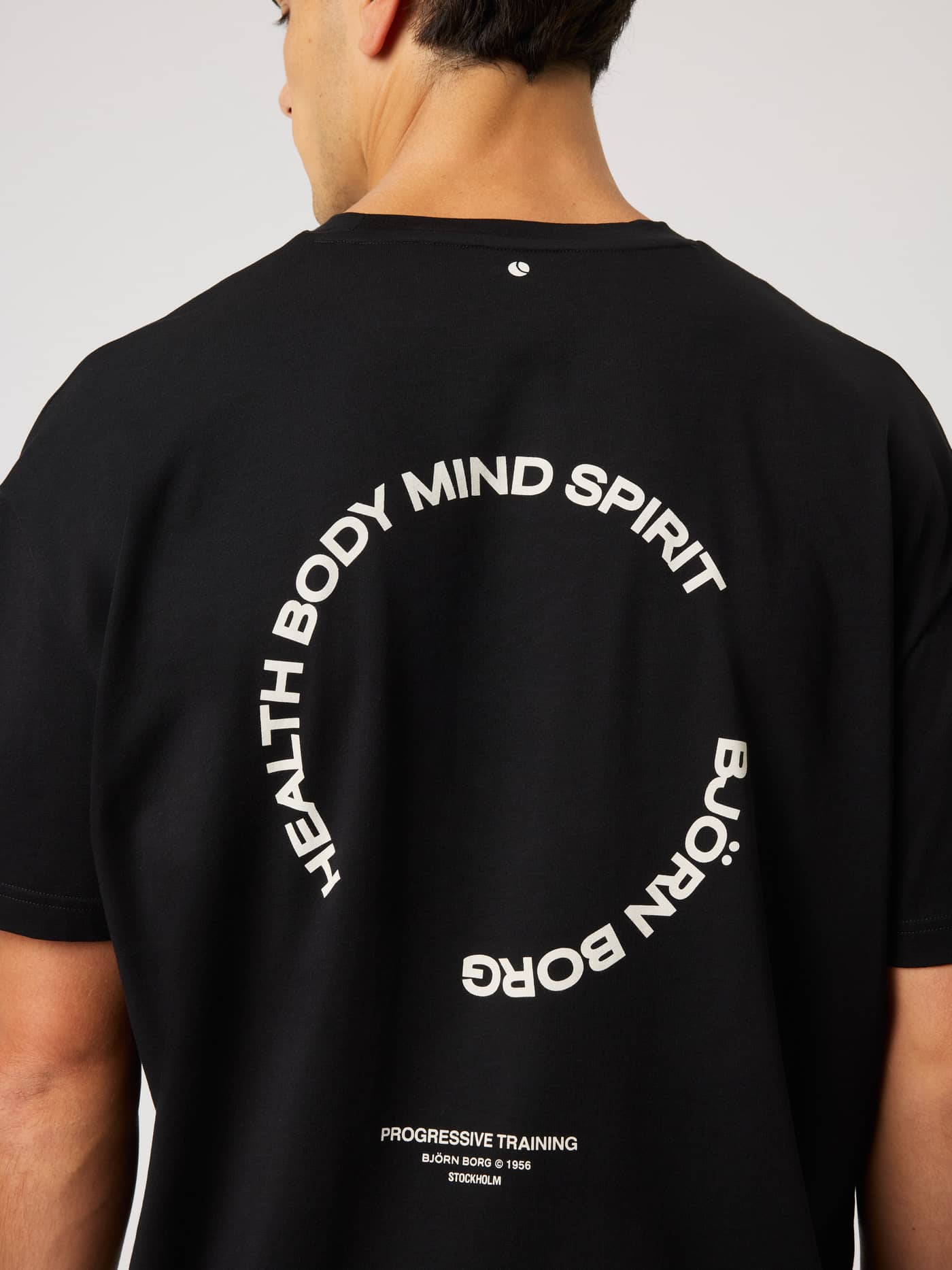 Back view of the Borg Gym Oversized T-Shirt in Black Beauty (Black) featuring white circular graphics for training. - Image 4