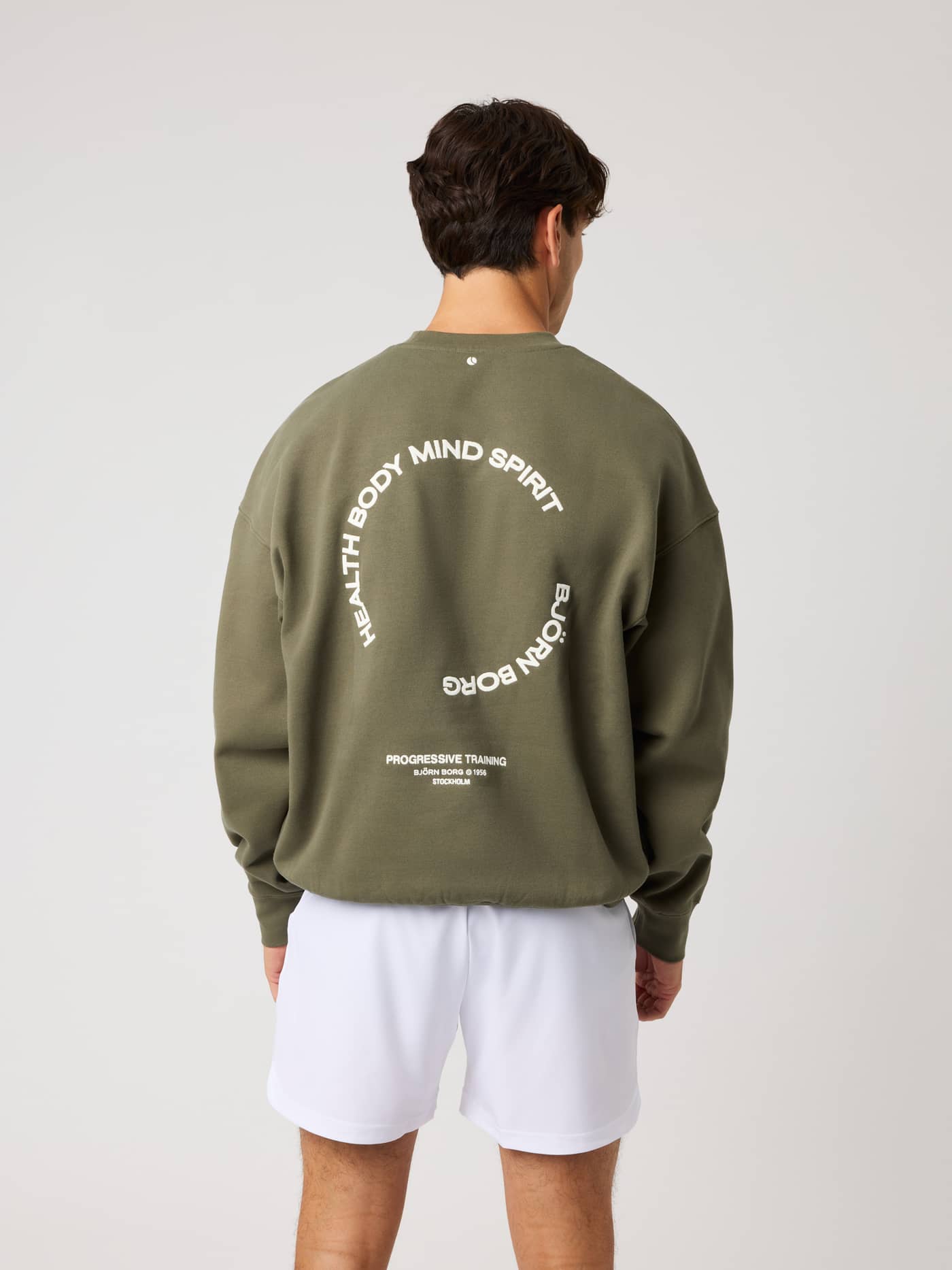 Back view of the Borg Oversized Sweatshirt in Kalamata (Green) featuring white circular training graphics on the back. - Image 3