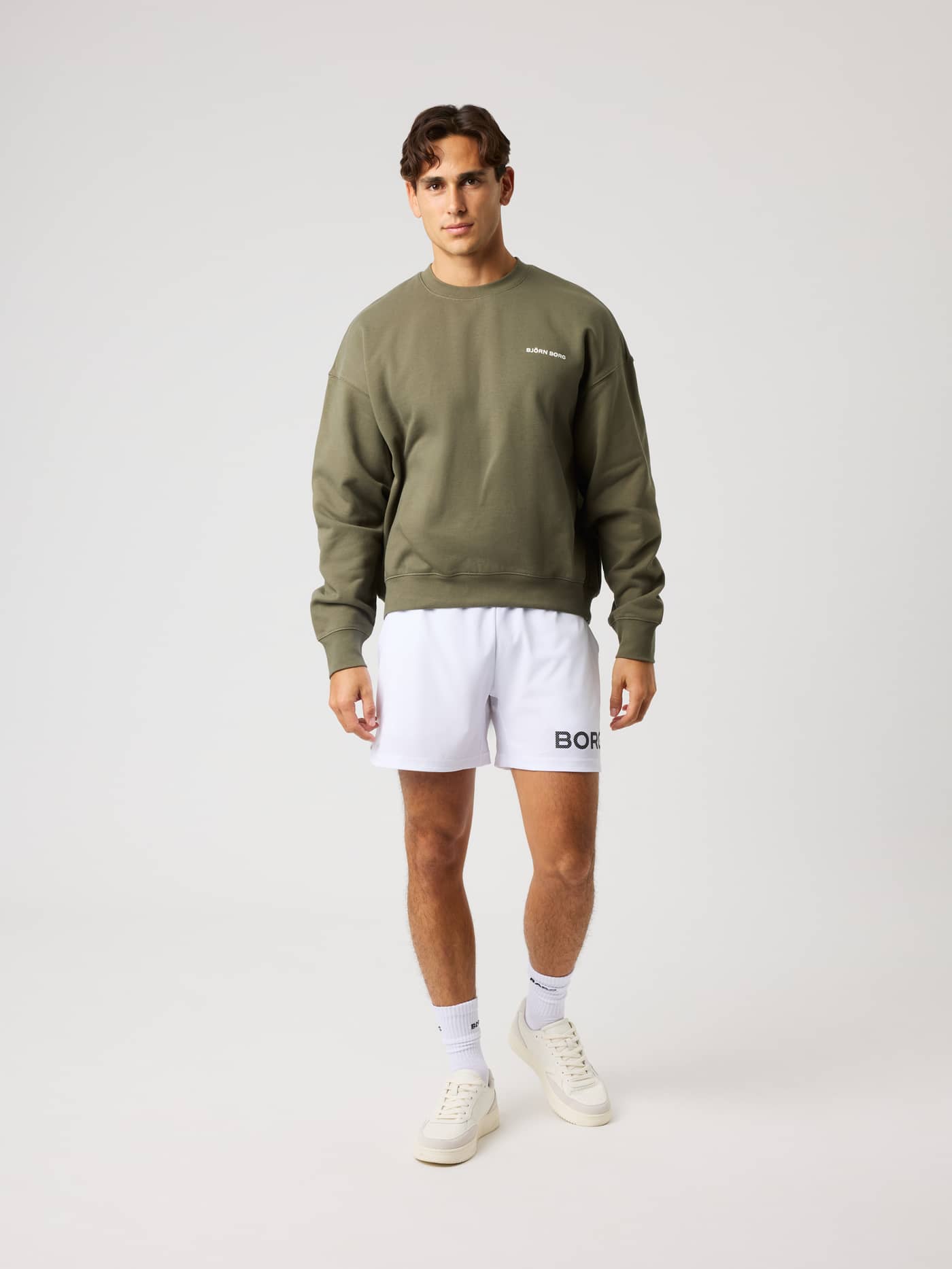 Full-body front view of a model in the Borg Oversized Sweatshirt in Kalamata (Green) with a white logo for training comfort. - Image 4