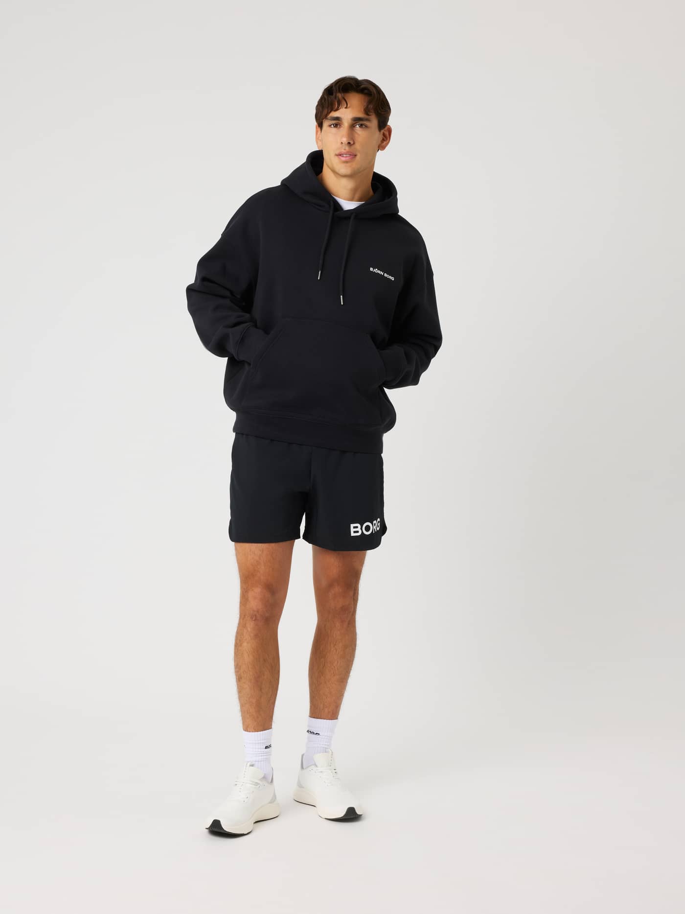 Full-body front view of the Borg Oversized Hoodie in Black Beauty (Black) with a white chest logo for training and tennis. - Image 5