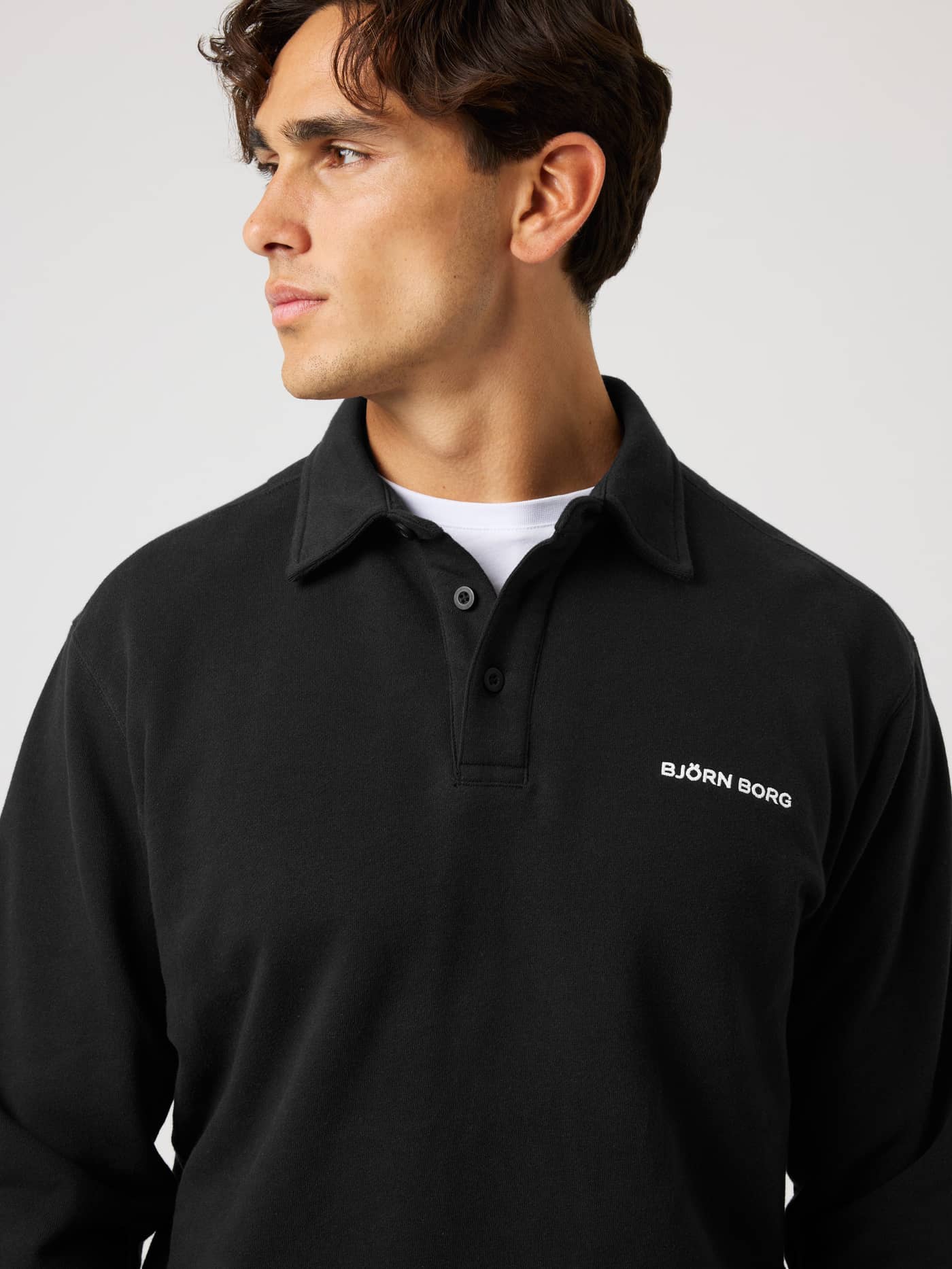 Close-up of the Borg Classic Polo Sweatshirt in Black Beauty (Black) with white logo embroidery for a tennis-inspired look. - Image 5