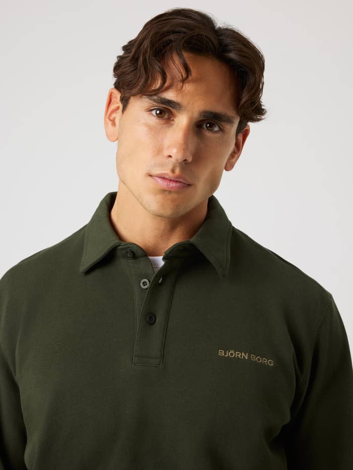 Model wearing the tennis-inspired cotton Borg Classic Polo Sweatshirt in Rosin (Green) with gold chest logo embroidery. - Image 5